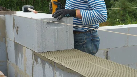 Bricklayer putting down another row of bricks in site Stock Footage 113402989
