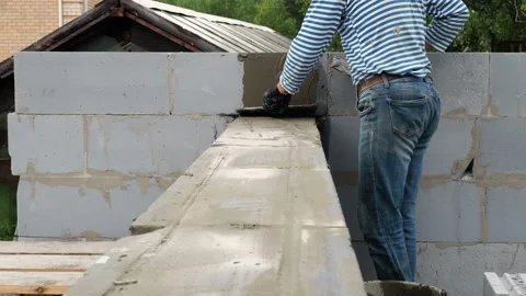Bricklayer putting down another row of bricks in site Stock Footage 113403227
