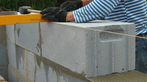 Bricklayer putting down another row of bricks in site Stock Footage 113403675