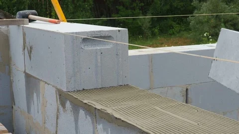 Bricklayer putting down another row of bricks in site Stock Footage 113403776