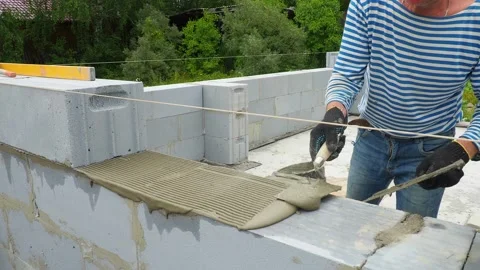 Bricklayer putting down another row of bricks in site Stock Footage 113405112