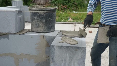 Bricklayer putting down another row of bricks in site Stock Footage 113405409
