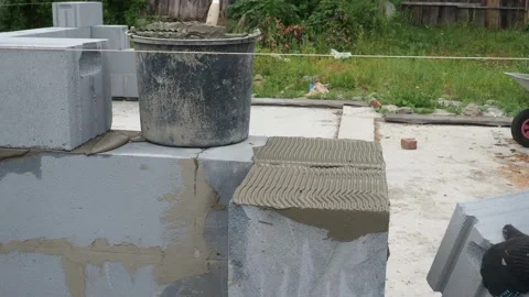 Bricklayer putting down another row of bricks in site Stock Footage 113405494
