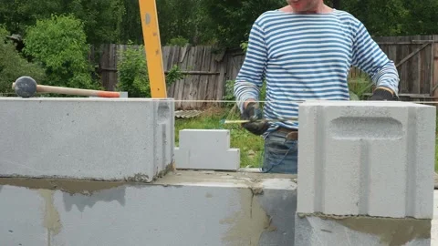 Bricklayer putting down another row of bricks in site Stock Footage 113405848