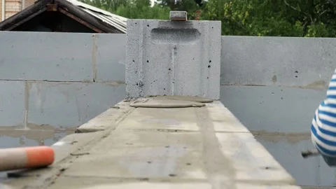 Bricklayer putting down another row of bricks in site Stock Footage 113407032