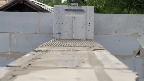 Bricklayer putting down another row of bricks in site Stock Footage 113411552