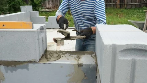 Bricklayer putting down another row of bricks in site Stock Footage 113411626