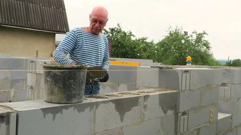 Bricklayer putting down another row of bricks in site Stock Footage 113412285