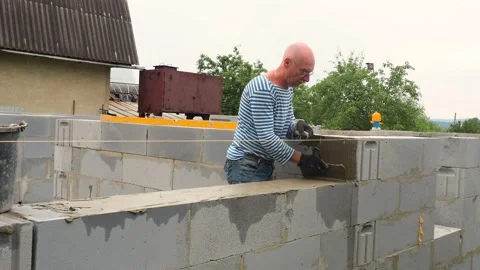Bricklayer putting down another row of bricks in site Stock Footage 113413570