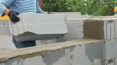 Bricklayer putting down another row of bricks in site Stock Footage 113414777