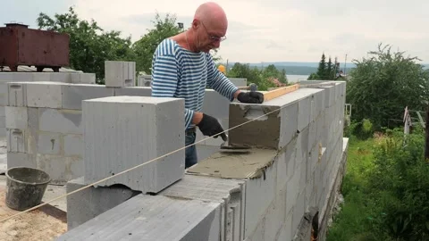 Bricklayer putting down another row of bricks in site Stock Footage 113415836