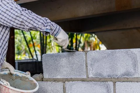 Bricklayer putting down another row of bricks in site Stock Photos