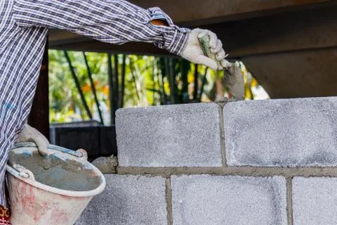Bricklayer putting down another row of bricks in site Stock Photos