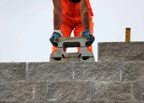 Bricklayer putting down another row of bricks in site during the construct... Stock Photos