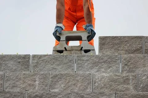 Bricklayer putting down another row of bricks in site during the construct... Stock Photos