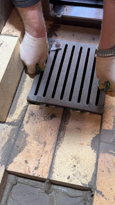 Bricklayer securing a cast-iron grate in the brickwork, Building a heating .. Stock Footage 321838062