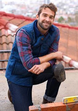 Bricklayer, smile and construction with man builder on roof, working employee in Stock Photos