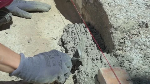 Bricklayer spreading fresh cement mortar with a trowel 库存影片 336408720