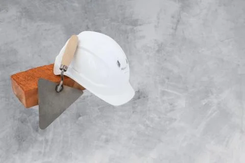 Bricklayer tools - trowel, bricks and white helmet on cement background. copy Stock Photos