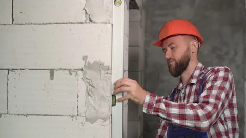 Bricklayer using spirit bubble level to precise check concrete blocks on wall Stock Footage 219921928