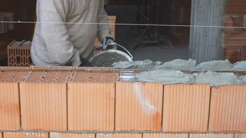 Bricklayer worker installing brick masonry on exterior wall with trowel putty Vídeo Stock 171854266