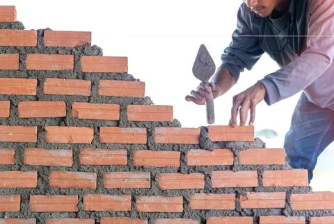 Bricklayer worker installing brick masonry with trowel putty knife. Foto stock