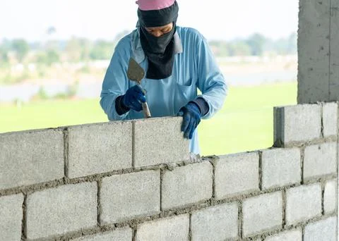 A bricklayer worker installing bricks of dormitory. Stock Photos