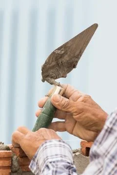 Bricklayer working in construction site of a brick wall Stock Photos