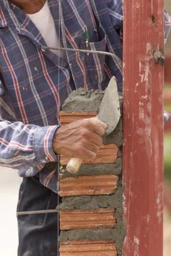Bricklayer working in construction site of  brick wall Stock Photos