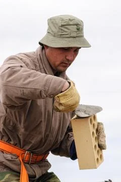 Bricklayer works on house construction Stock Photos