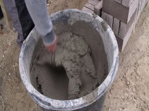 Bricklayer's hand mixing mortar at construction site in Europe Stock Footage 75807235