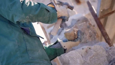 Bricklayer's hands breaking stones with hammer Stock Footage 76557339