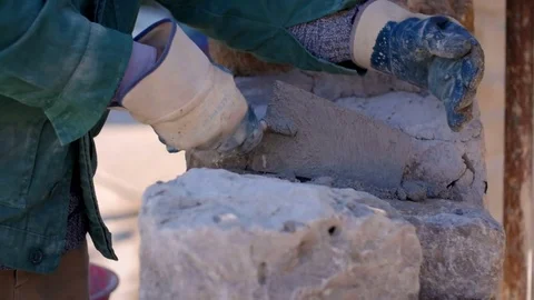 Bricklayer's hands placing lime with a trowel Stock Footage 76559388