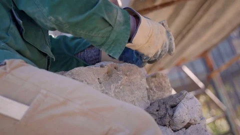 Bricklayer's hands placing stones on a wall Stock-Footage 76558727