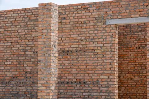 Bricklayers work diligently to create a strong wall structure, highlighting.. Stockfoto's