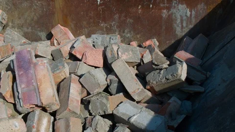 Bricks and Demolition Rubble Tipped into a Skip on a Construction Site Stockbeeldmateriaal 107768594