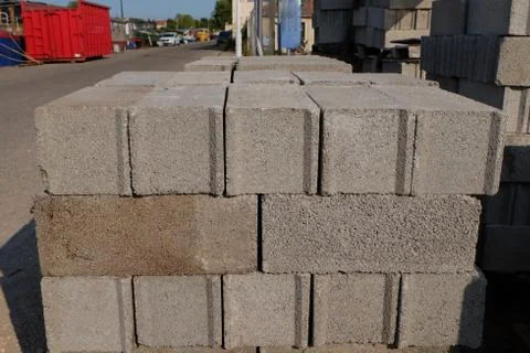 Bricks are placed together in a large pile waiting for use in construction. Stock Photos