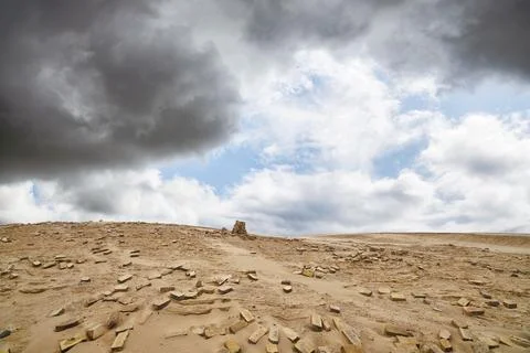 Bricks in a dry desert in cloudy weather with a stack of stones 스톡 사진