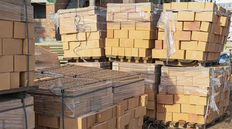 Bricks in pallets on a construction site. Construction Materials. Stockfoto's