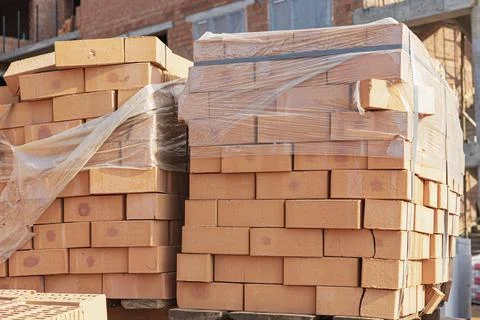 Bricks in pallets on a construction site. Construction Materials. Stock Photos