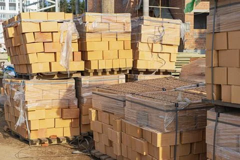 Bricks in pallets on a construction site. Construction Materials. Stock Photos