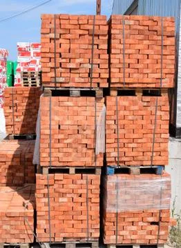 Bricks on pallets. Storage of bricks at construction site. Stock Photos