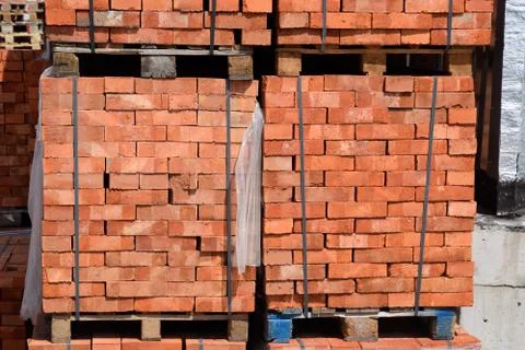 Bricks on pallets. Storage of bricks at construction site. Stock Photos