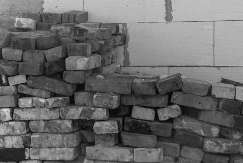 Bricks piled against a white wall close up Stock Photos