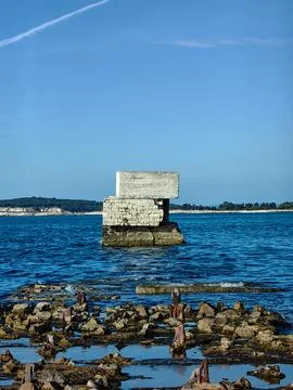 Bricks of ruined breakwater in Pula, sharp damaged stones. Stock Photos