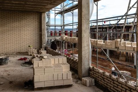 Bricks on scaffolding ready to be placed in facade Stock Photos