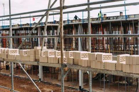 Bricks on scaffolding ready to be placed in construction site Stock Photos