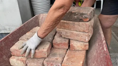 Bricks taken from red wheelbarrow Stock Footage 316539225