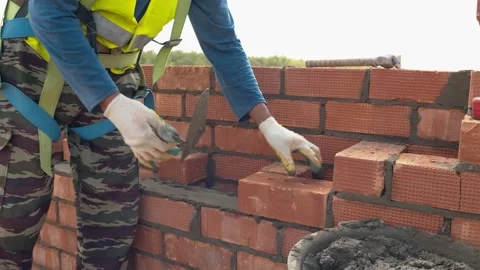 Brickwork on the background of the tops of green trees. Development of suburban Stock Footage 157345715
