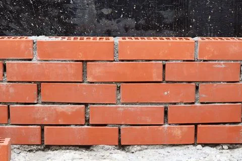Brickwork close-up. Construction of a wall of red ceramic bricks. selective f Stock Photos